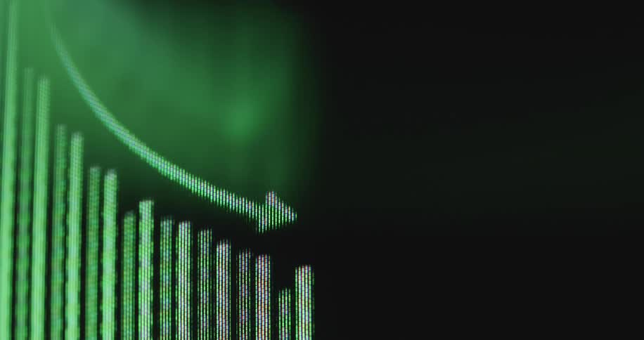 A close-up of a digital screen shows a green bar chart with a downward arrow indicating a decline