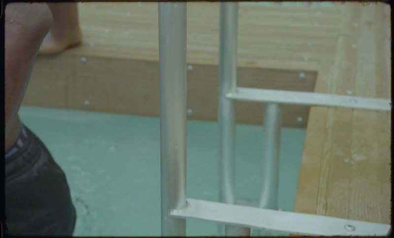 A determined man takes a cold plunge in a wooden outdoor tub for wellness and recovery