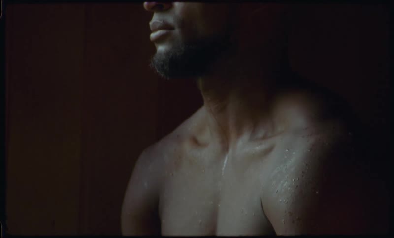 A muscular man meditates and detoxifies his body while sweating in a hot, steamy sauna
