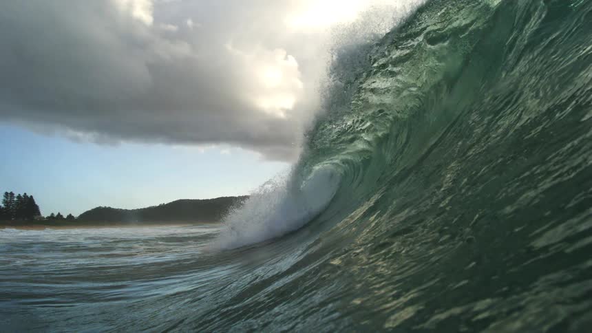 A majestic ocean wave curls and breaks in stunning super slow motion, captured from an immersive perspective in the water