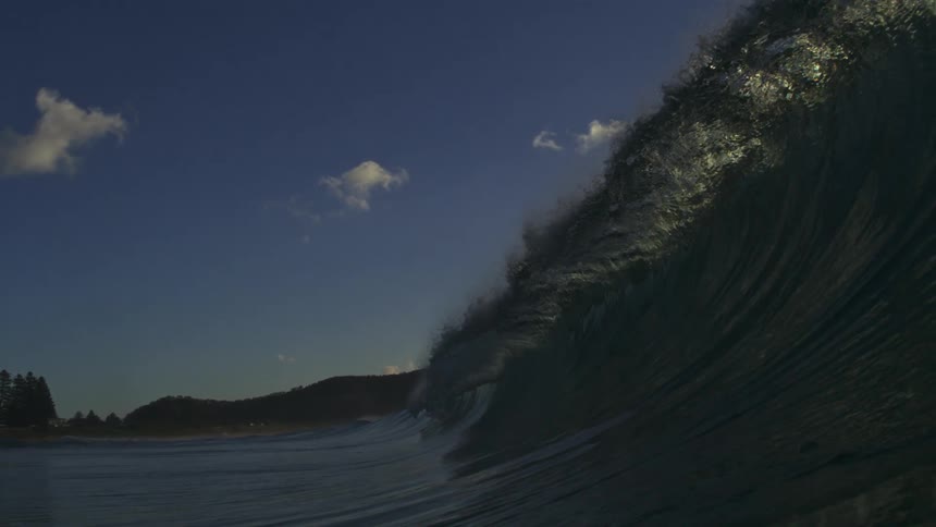 A powerful ocean wave curls into a perfect barrel in stunning super slow motion as seen from inside the water