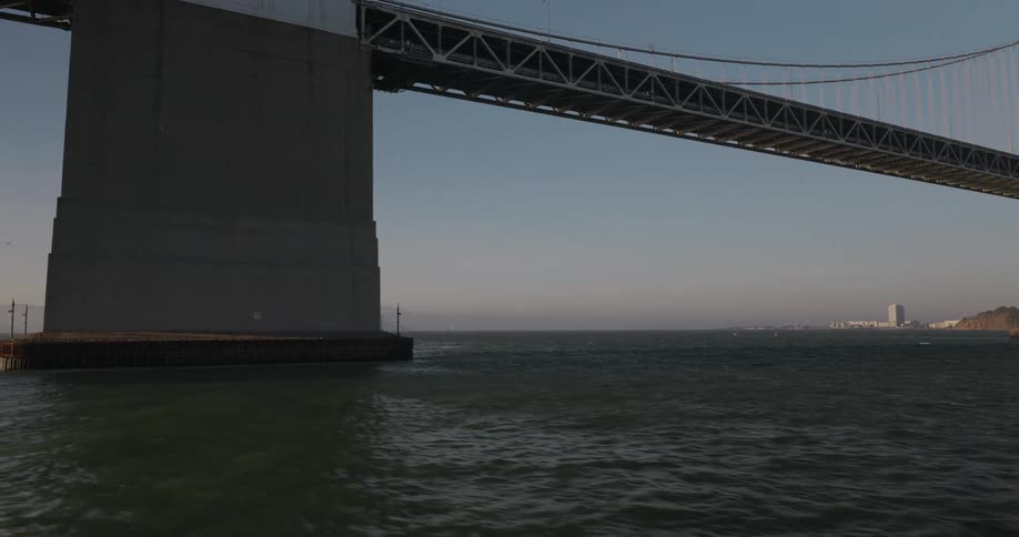 A slow pan across the water reveals the impressive architecture of the San Francisco-Oakland Bay Bridge on a clear day