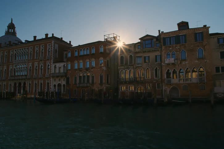A stunning timelapse captures the sun setting behind the historic buildings along the Grand Canal in Venice, Italy
