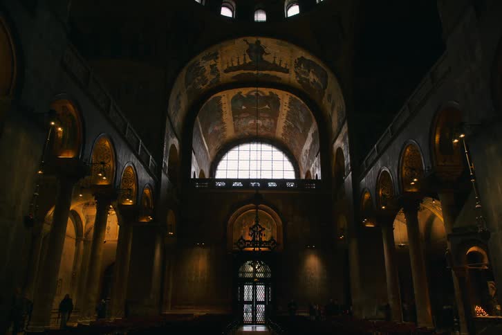 A majestic and atmospheric wide shot of the dimly lit interior of a historic European cathedral