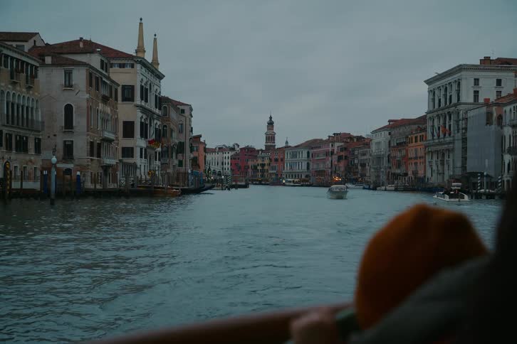 A scenic view from a boat traveling down the Grand Canal in Venice, Italy, on a moody and overcast day