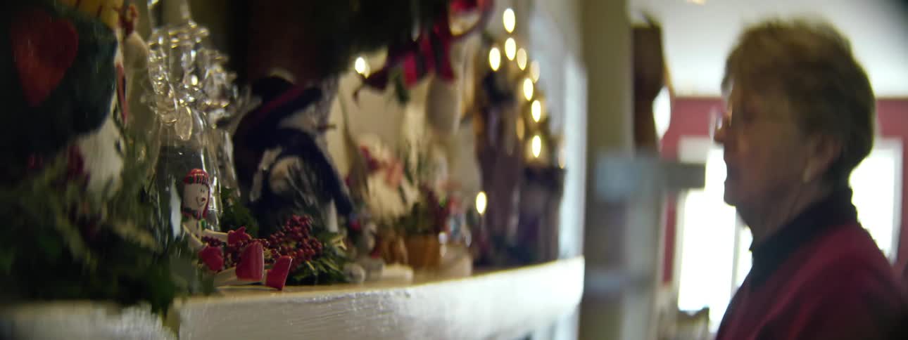 A woman places ornaments on a mantle