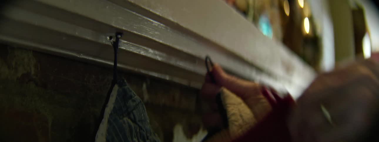 A person attaches stockings to a chimney
