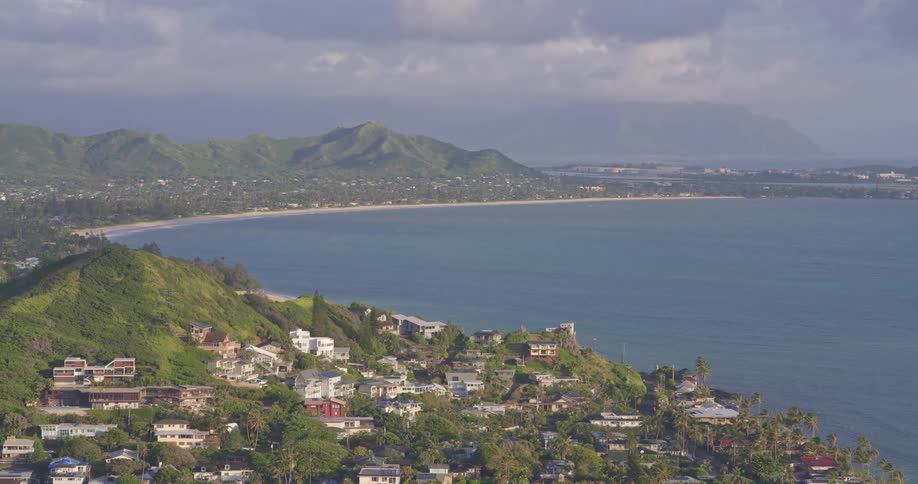 A stunning elevated view of the beautiful Lanikai Beach and Kailua Bay on the island of Oahu, Hawaii, with homes dotting the lush green hillsides