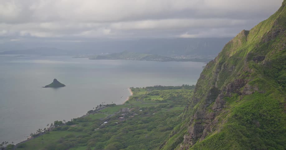 A majestic high-angle view from a lush green mountain overlooking the Hawaiian coastline and the iconic Chinaman's Hat island
