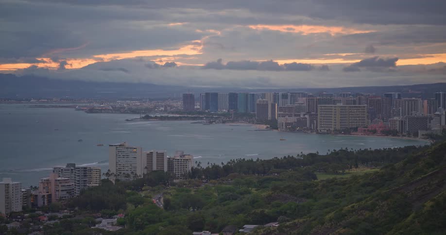 Panoramic view of Honolulu and Waikiki under a dramatic cloudy sky during a beautiful sunset