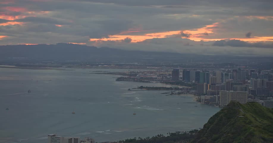 A dramatic cloudy sunrise over the city of Honolulu and Waikiki beach, viewed from the iconic Diamond Head crater in Hawaii