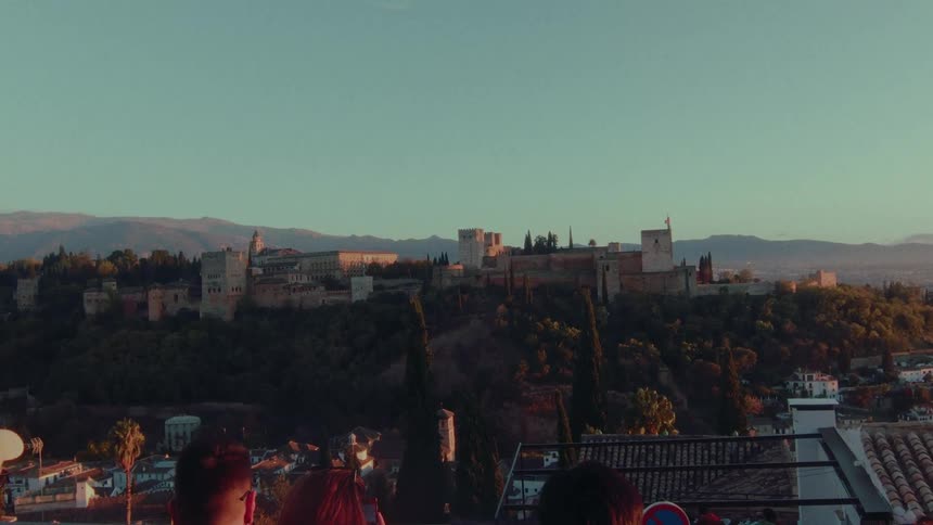A scenic view of the historic Alhambra palace in Granada, Spain, bathed in the warm light of a beautiful sunset