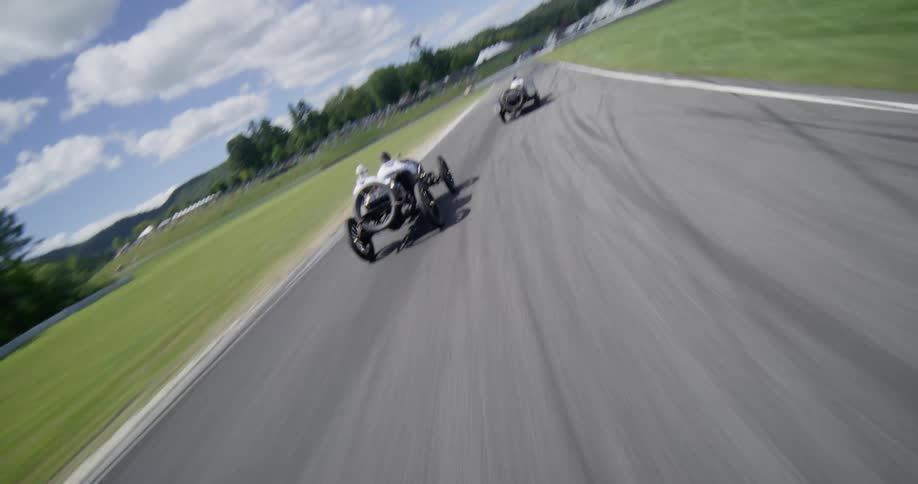 Thrilling aerial and on-board views capture vintage race cars speeding around a scenic racetrack during an exhilarating competition
