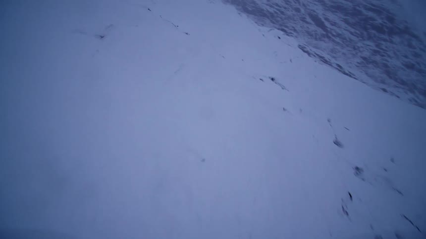 A dramatic FPV drone flight swoops over the dark, icy surface of a massive snow-covered glacier
