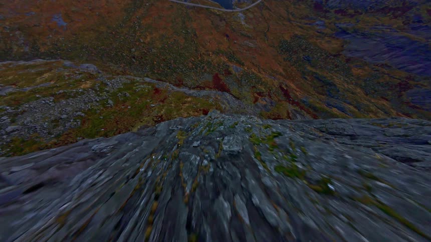 A thrilling FPV drone dive down a steep, snow-dusted mountain peak towards a serene lake and vast valley below