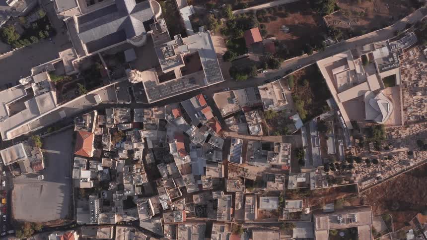 A breathtaking top-down aerial shot slowly rises above the rooftops of the ancient city of Nazareth