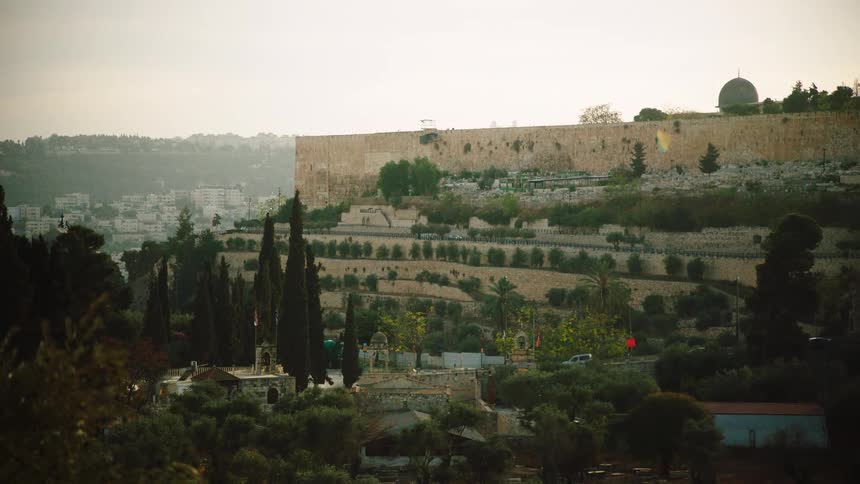 Traffic moves along a road at the base of the ancient walls of the Old City of Jerusalem in Israel