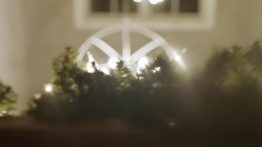 Light shines behind christmas garlands