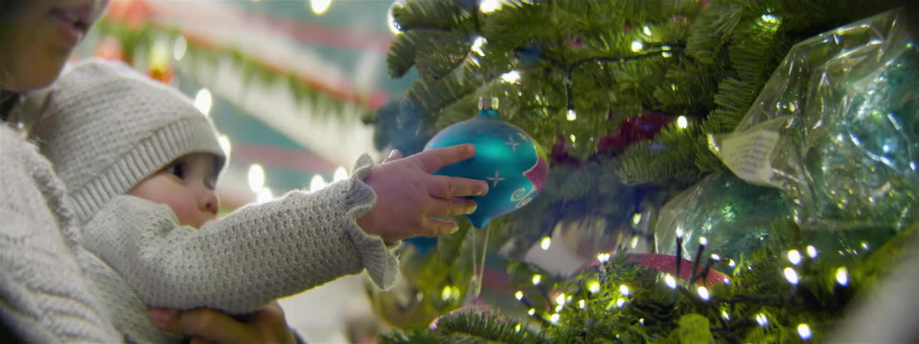 A baby plays with a blue ornament