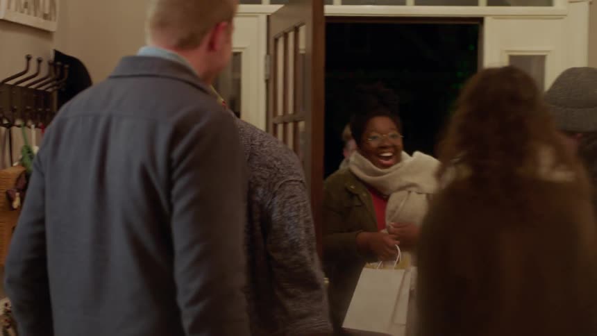 People greet each other in the foyer of a house