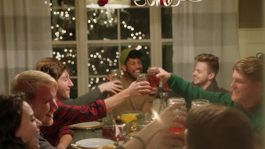 Friends raise a toast and clink glasses at a dinner party