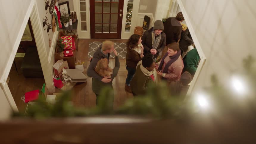 Friends greet each other at a party in a house