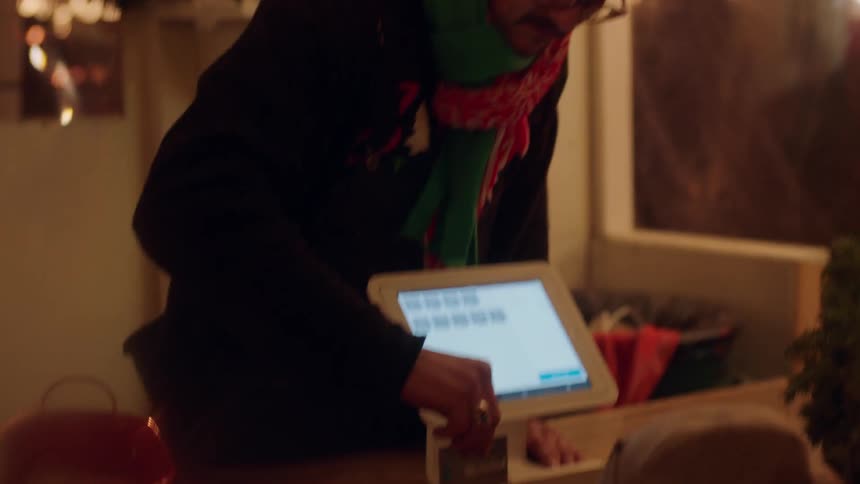 Clerk swiping a person's credit card on electronic machine in store