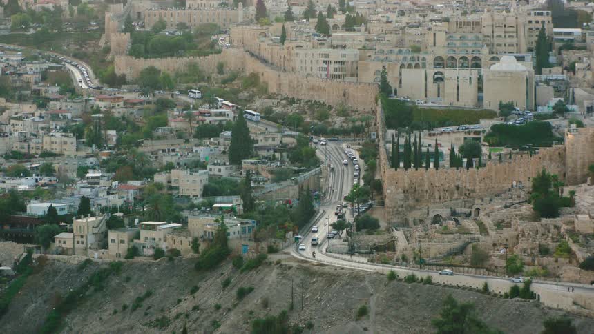 High-angle view of the historic walled Old City of Jerusalem with traffic moving on the road below