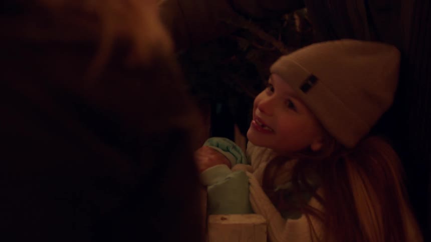 A young girl smiles as she peers over a countertop