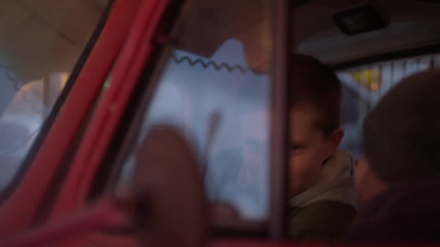 A boy is pressing the horn in a truck