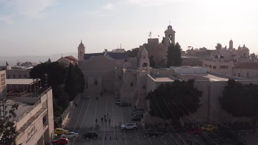 Aerial pullback shot reveals the historic Church of the Nativity in the ancient city of Bethlehem
