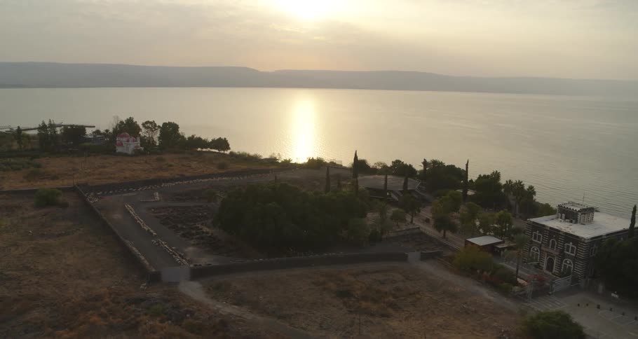 A slow aerial approach to the ancient ruins of Capernaum on the shores of the Sea of Galilee at sunrise