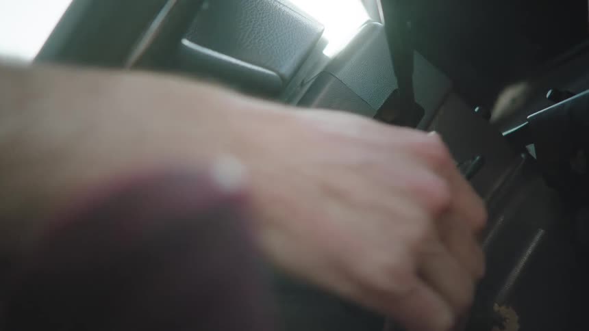 A close-up slow motion shot of a man's hand inserting and turning the key to start and stop the car's engine