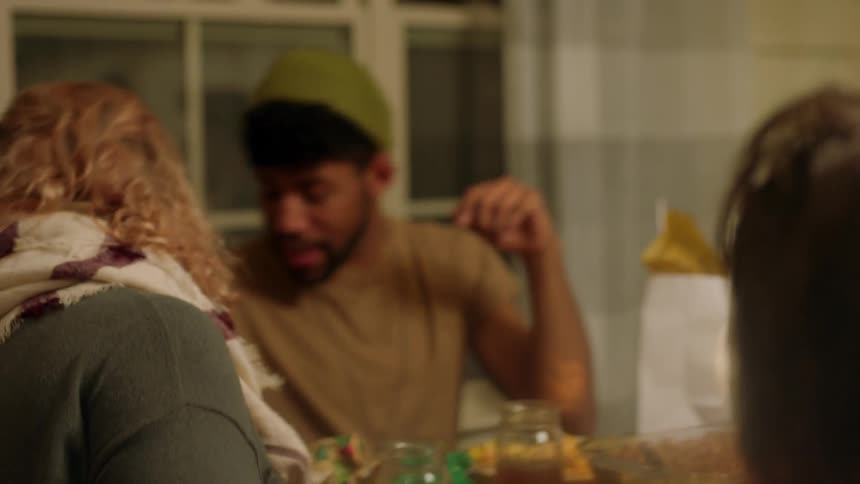 People sitting at dinner table are talking and laughing