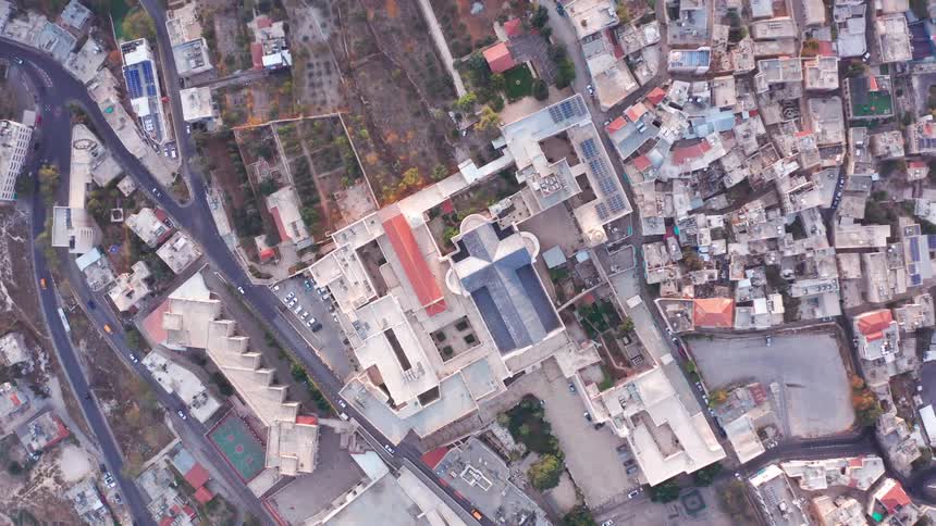 Aerial top-down drone view slowly ascending above the Basilica of the Annunciation in the city of Nazareth, Israel