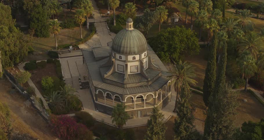 A stunning aerial view orbits the iconic Church of the Beatitudes in Israel, surrounded by lush gardens and illuminated by the warm light of the rising sun