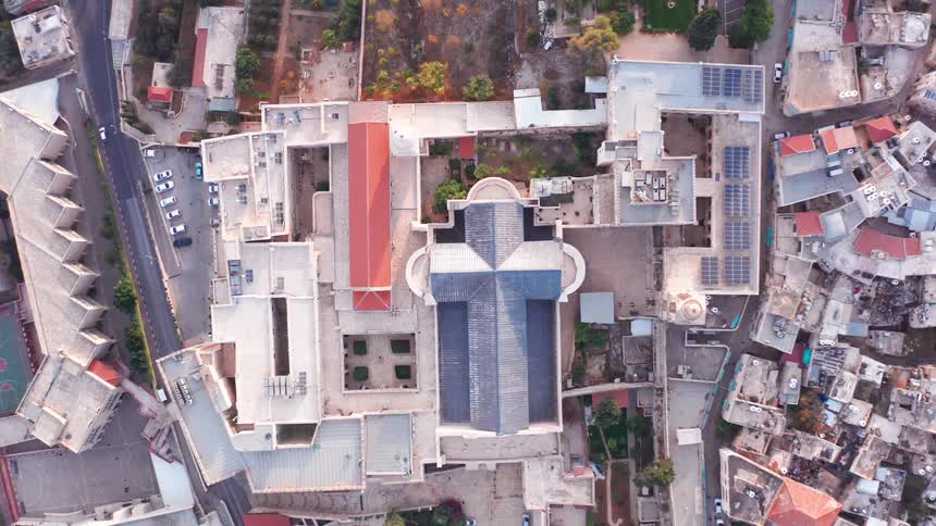 A static top-down aerial view of the cross-shaped Basilica of the Annunciation in the heart of Nazareth, Israel
