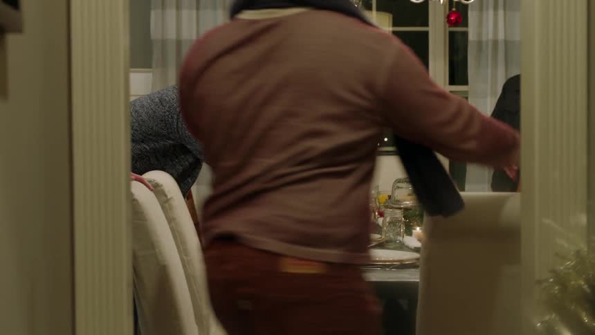 People walk into a dining room carrying dishes of food