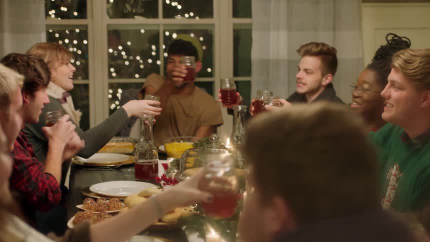 A group of people toast in the dining room of the home