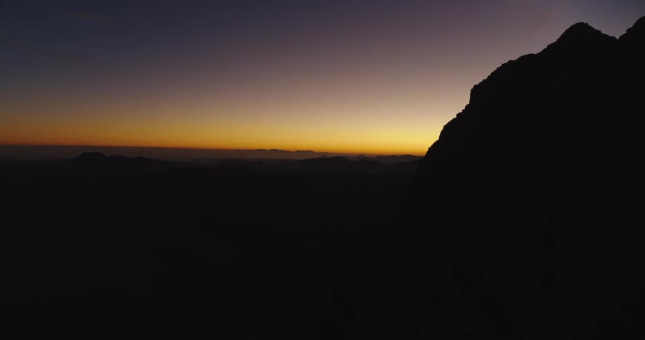 Majestic time-lapse captures the first light of dawn breaking over a vast mountain range