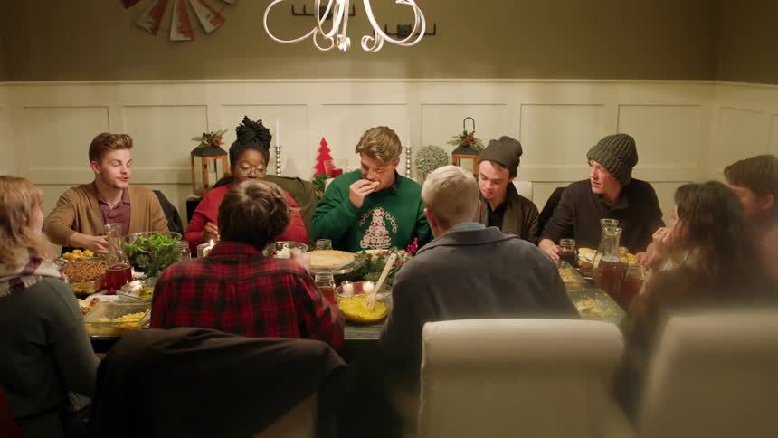 Large group of people sharing a holiday meal at a large dining table