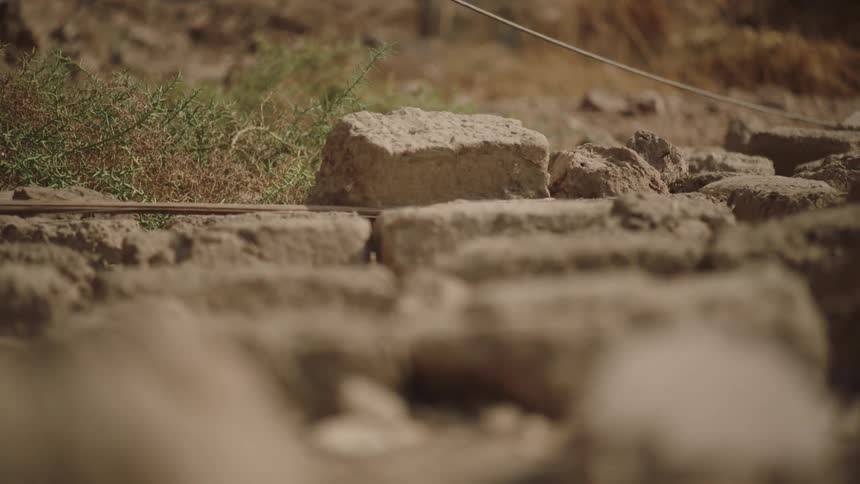 A slow-moving, shallow-focus close-up shot of ancient mud bricks at a historical archaeological site