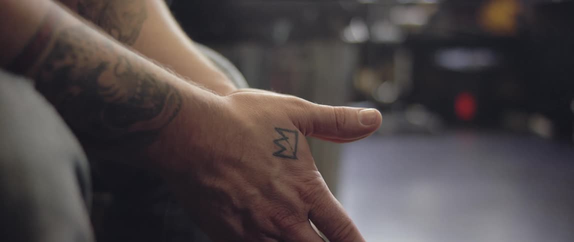 Man with tattoos rubbing his hands together