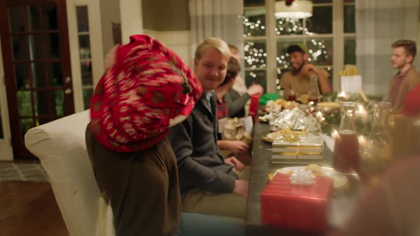 A woman tries on a christmas sweater and laughs
