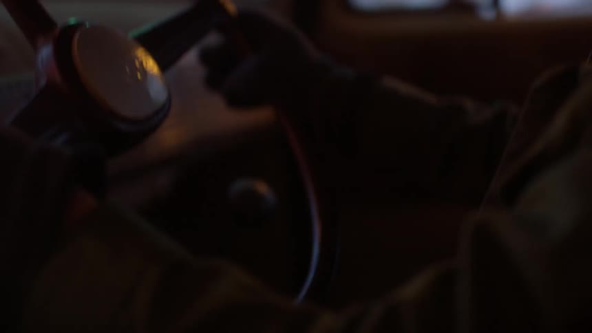 Child sits at the steering wheel of truck smiling