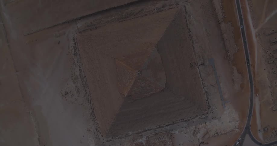 Top-down aerial drone footage slowly rises above the Great Pyramid of Giza, revealing the surrounding desert landscape
