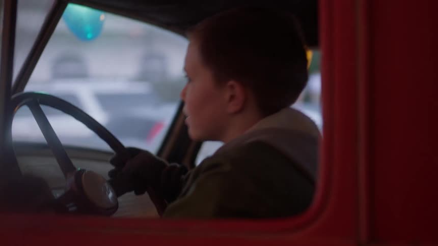 Child sits at the steering wheel of truck smiling