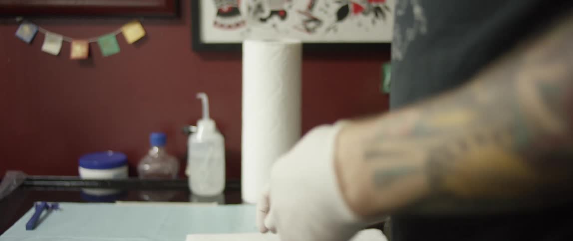 Tattoo artist putting on gloves