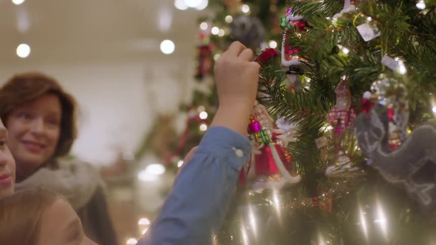 A girl takes an ornament off the tree in a shop