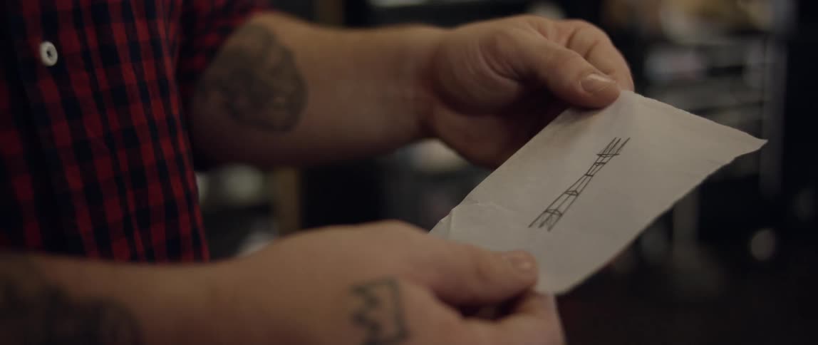 Man looking at a piece of paper with a symbol drawn on it